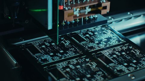 Factory Machinery at Work: Printed Circuit Board Being Assembled with Automated Robotic Arm, Surface Mounted Technology Connecting Microchips to the Motherboard. Macro Close-up Footage.