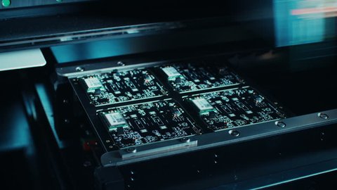 Factory Machine at Work: Electronic PCB Being Assembled with Automated CNC Robotic Arm, SMT Connecting Microchips to the Motherboard. Time Lapse Macro Close-up Footage. Shot on 4K (UHD) Camera