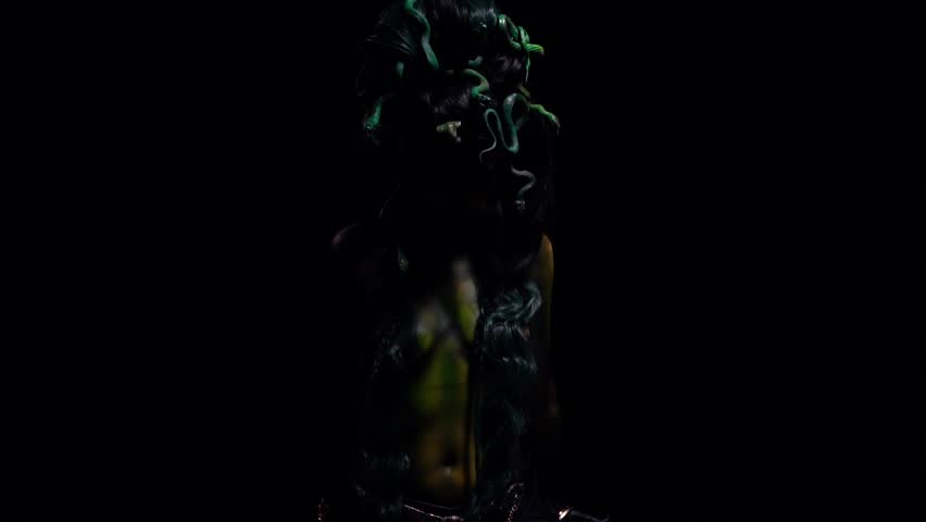 Ancient Medusa Gorgon spreads and lifts her arms up