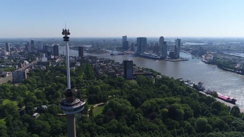 Aerial bird view flight past Euromast popular tourist attraction in Rotterdam the second largest city in Netherlands in South Holland heading towards Erasmusbridge and Noordereiland in background 4k