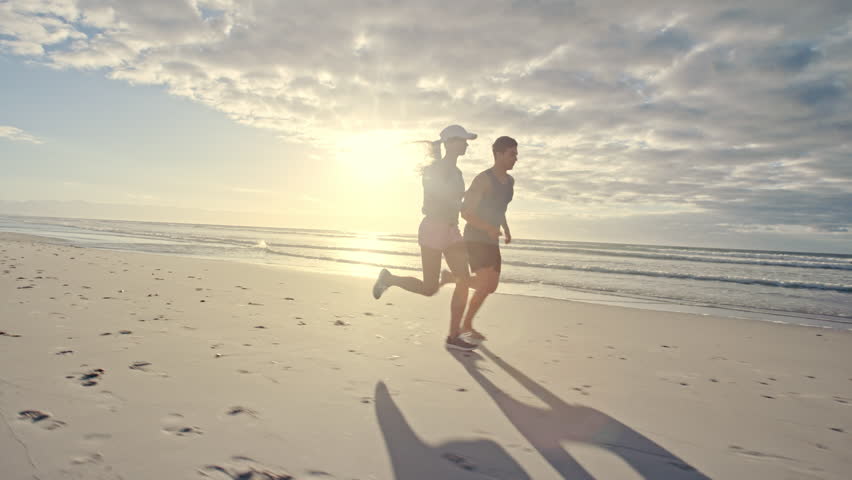 Fit young man and woman running on the beach. Young couple jogging on the sea shore.
 | Shutterstock HD Video #1019329849