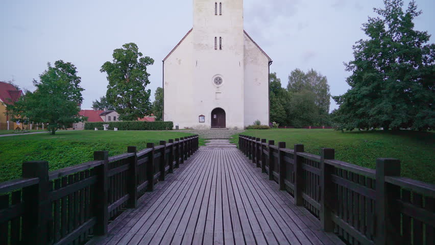 The black door of the small chapel in the lawn with the small bridge in front
