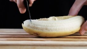 Chef is cutting banana in the kitchen, close up footage