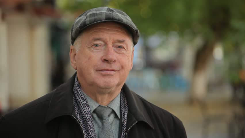  Exciting bokeh view of an optimistic white-haired man in a plaid cap, black coat and a necktie smiling and taking off his cap in autumn | Shutterstock HD Video #1019356081