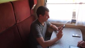 Casual man reading from mobile phone screen while reads sms message traveling on train wagon. slow motion video. lifestyle Wireless social media internet web on public transport concept . train wagon