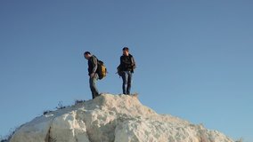 two men tourists hiking adventure climbers climb the mountain. slow motion video. hiker walking goes on nature on the hill white lifestyle rock. extreme outdoor activity sport concept tourist