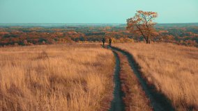 people tourists travel in nature the autumn go on the road path adventure. slow motion video. two hiker outdoor lifestyle with backpacks hiking. tourist concept the travel man tourism