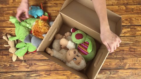 Woman is preparing to donate unwanted toys to charity shop, top view video