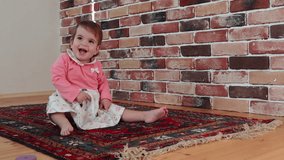 Cute baby girl is crawling on floor at home, slow motion video