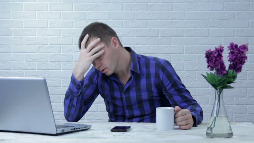 Upset Young Man Covers His Face with Palms in Frustration, While Getting Bad News from Reading Bad News on a Laptop | Shutterstock HD Video #1019370388