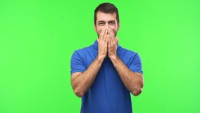 Man on green screen chroma key background smiling a lot while covering mouth