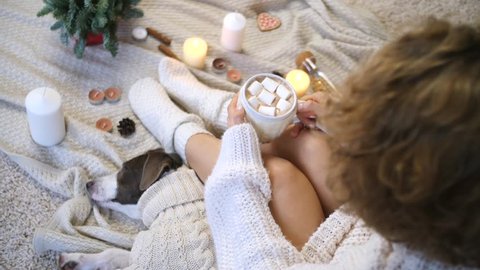Female In Knit Sweater And Socks Holding Hot Cacao Cup At Home