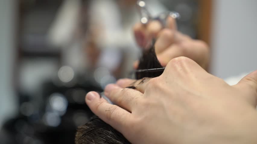 Brunette man getting a haircut by a hairdresser with scissors. | Shutterstock HD Video #1019391565