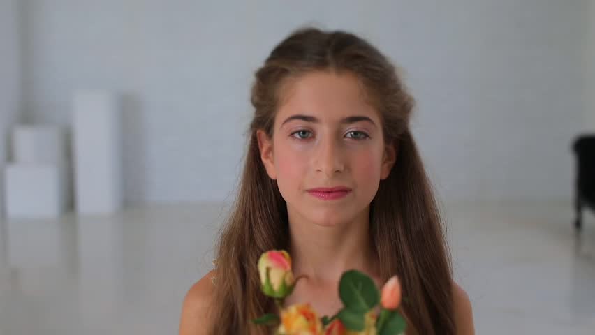 Portrait of a tween girl with flowers  becoming bat mitzvah 12 yo. She looks into the frame. Shooting in studio like a present from parents.
Traditional and necessary rituals of modern Jews. Royalty-Free Stock Footage #1019398645