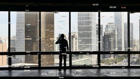 4k a businessman Businessman making a call,overlooking the urban building,skyscrapers Scene.a financial tech digital data globe,tech network,complexity and data flood of digital age.Business figures.  - Powered by Shutterstock - Get 15% off with code: PIKWIZARD15