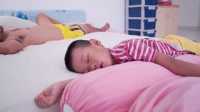 Five years old Asian boy sleeping on bed with father, footage video.