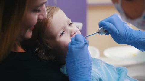 Dentistry. Female dentist examines the oral cavity of little baby