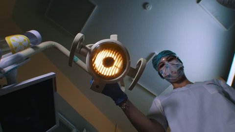 A dentist turns on the lamp and coming closer to the patient holding tools. First person shooting Video Stok
