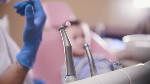 Dentistry, medicine. Dentist takes the polishing instrument from the stand. Slow motion. Close up