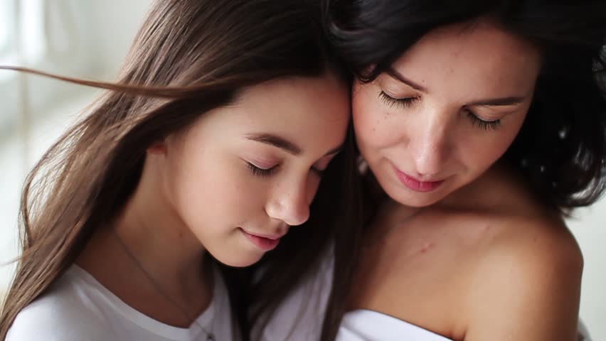 Beautiful closed eyes mom and daughter hugging showing love and affection in white studio smile happy family mother together cute pretty teenager portrait close up slow motion | Shutterstock HD Video #1019414443