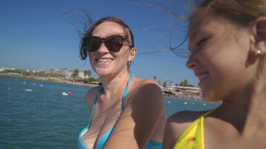 Happy girl with her mother sailing on the sea on a boat to the shore. | Shutterstock HD Video #1019421109