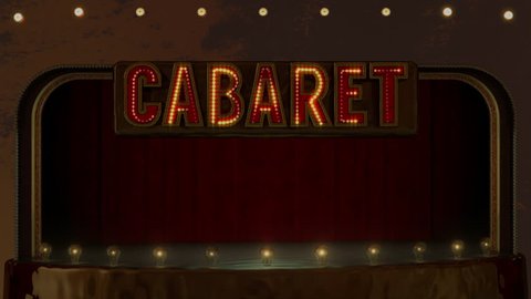 Red bold Cabaret sign with twinkling yellow lights above empty stage surrounded by large round light bulbs and dark red curtains