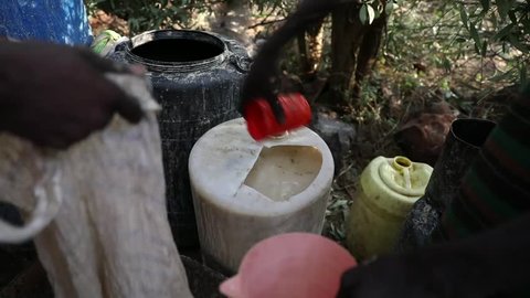 Marigat, Baringo County, Kenya - October 2, 2018: Men prepare and drink a home made alcholic brew  during a traditional ceremony in a Pokot community. 