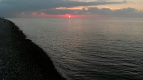 Beautiful background video: red sunset sky above Black Sea, Georgia. Aerial video, 4K.  Epic sunset over sea, drone flight. 