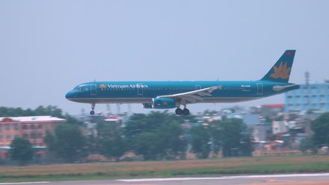 HANOI AIRPORT, VIETNAM, MARCH 2017: Big blue commercial airplane lands on the empty runway on a sunny day in Vietnam. Vietnam Airlines aircraft speeding towards the runway to land at Hanoi airport.