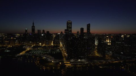 Chicago Circa-2015, aerial view of the Chicago Loop skyline at night from Lake Michigan, moving toward Grant Park, Buckingham Fountain and the Willis Tower in the distance