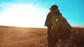 Silhouette hiker man of backpacker. steadicam motion video sunlight sunset person side view walking toward successful. lonely man with sunset background.Travel and success lifestyle concept the