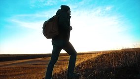 Silhouette hiker man of backpacker sunlight. steadicam motion video sunlight sunset person side view walking toward successful. lonely man with sunset background. Travel and success concept lifestyle