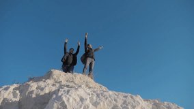 two lifestyle men tourists hiking adventure climbers climb the mountain . slow motion video. hiker walking goes on nature success hand to hand freedom up on the hill white rock. extreme outdoor