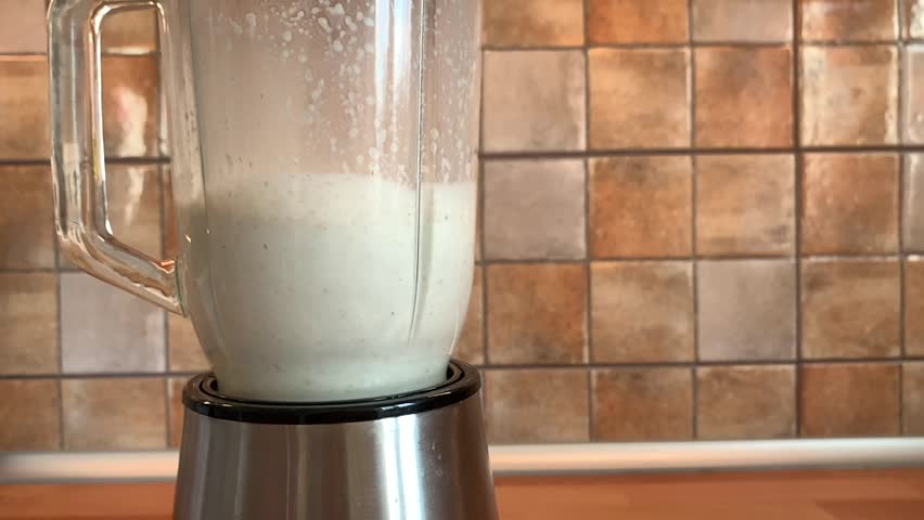 Blending oatmeal smoothie on the kitchen, slow motion video