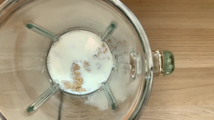 Blending oatmeal smoothie, top view slow motion video