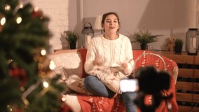 Girl blogger sitting at home on the couch, talks about the new year and Christmas.
