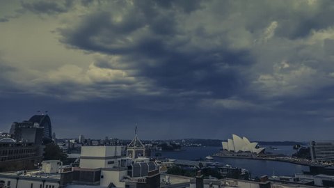 AUSTRALIA, SYDNEY - APRIL 19, 2018: Timelapse of Sydney Harbour as it gets dark with famous Sydney Opera House. Dramatic clouds and rain sweeping across the sky. Illustrative editorial footage.