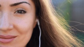 Woman closeup in headphones smiling and listening music