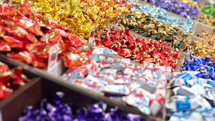 Large choice of sweets in a candy shop. Close-up of lots of candy in colorful wrappers in a pastry shop. Supermarket. | Shutterstock HD Video #1019491687