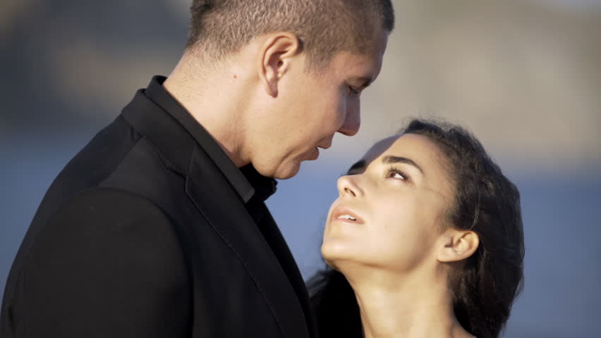 Portrait newlywed couple standing and embracing on the beach