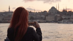 young woman shoots boat sailing past in Istanbul