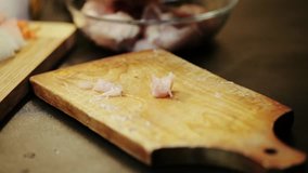 Slicing chicken breast on a wooden board