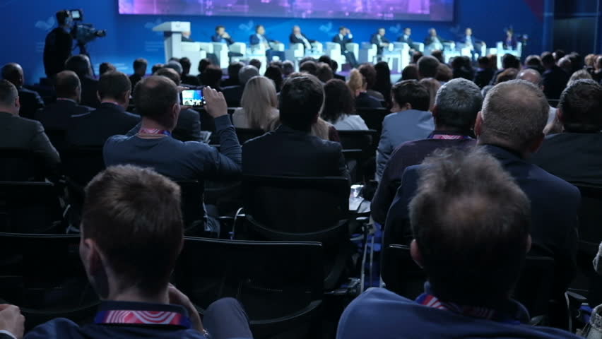 People on the forum on business development. Hall is full. View from the back of auditorium with people at a conference or presentation, master class. International economic business forum Royalty-Free Stock Footage #1019501278