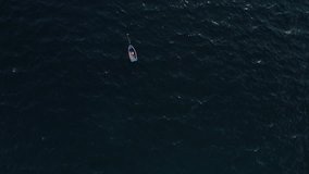 This stock footage presents an aerial shot of speed boats floating on water. The shot zooms out to reveal the rippling ocean. Use this clip as an establishing shot in movies, it comes in 4K