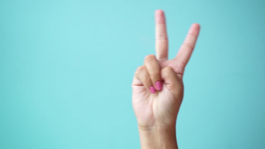 Closeup of isolated on green adult female hand counting from 0 to 5. Woman shows fist fist, then one, two, three, four, five fingers. Manicured nails painted with beautiful pink polish. Math concept.