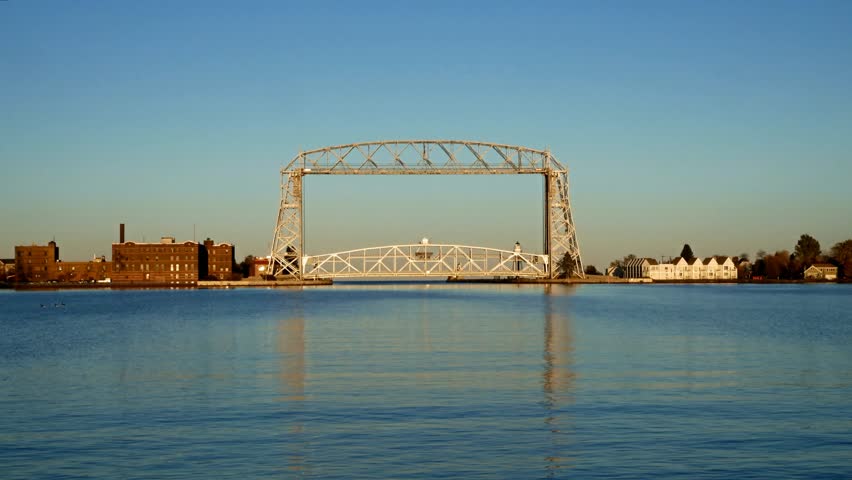 Two clips of the Iconic Duluth Minnesota Aerial Lift Bridge and Duluth Harbor on a calm sunny afternoon under blue skies.