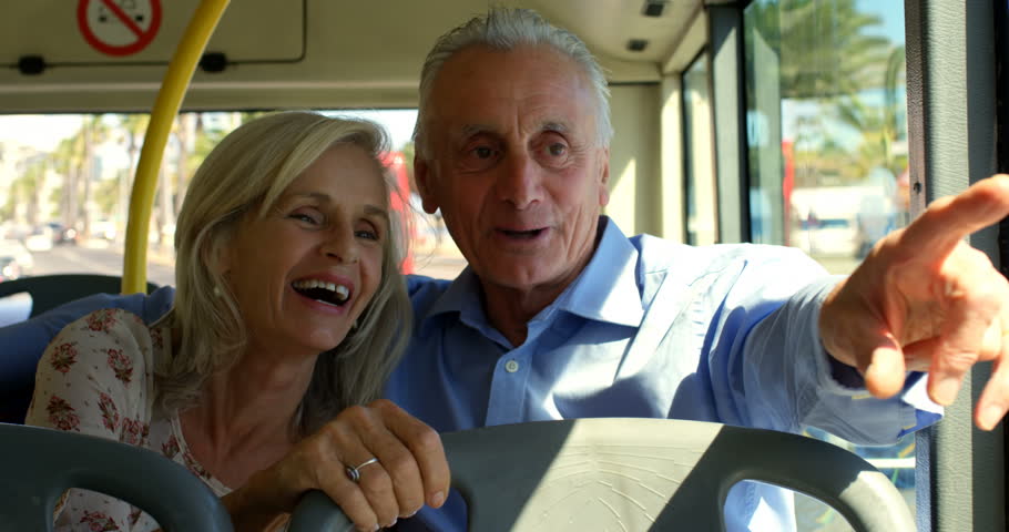 Front view close up of happy senior Caucasian couple interacting with each other while travelling in bus 4k