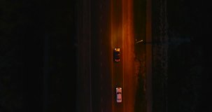 Flying over the roadway with cars at night. Beautiful aerial view on the night road.
