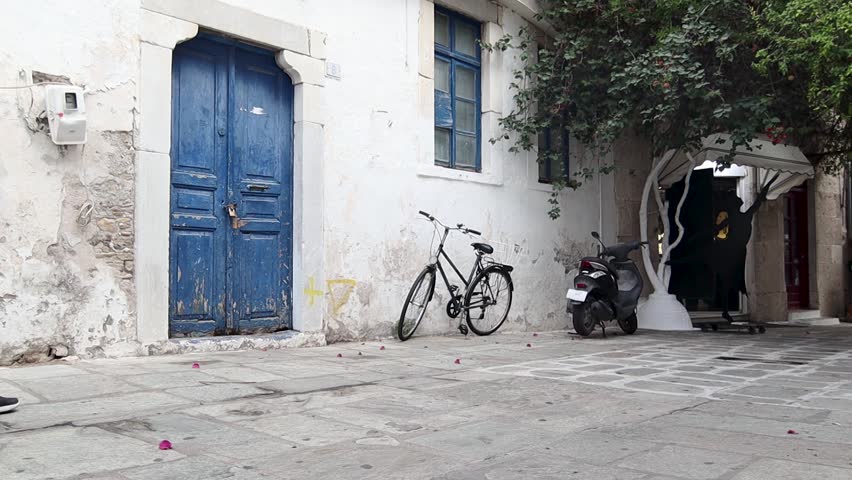Young woman with a backpack is walking down the street at the old city of Kos, Greece.