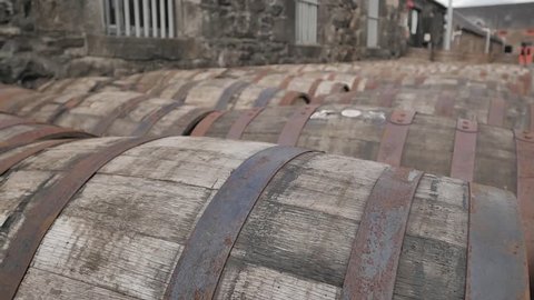 Aging Wooden Whiskey Barrels Lying on Sides Outside a Distillery
